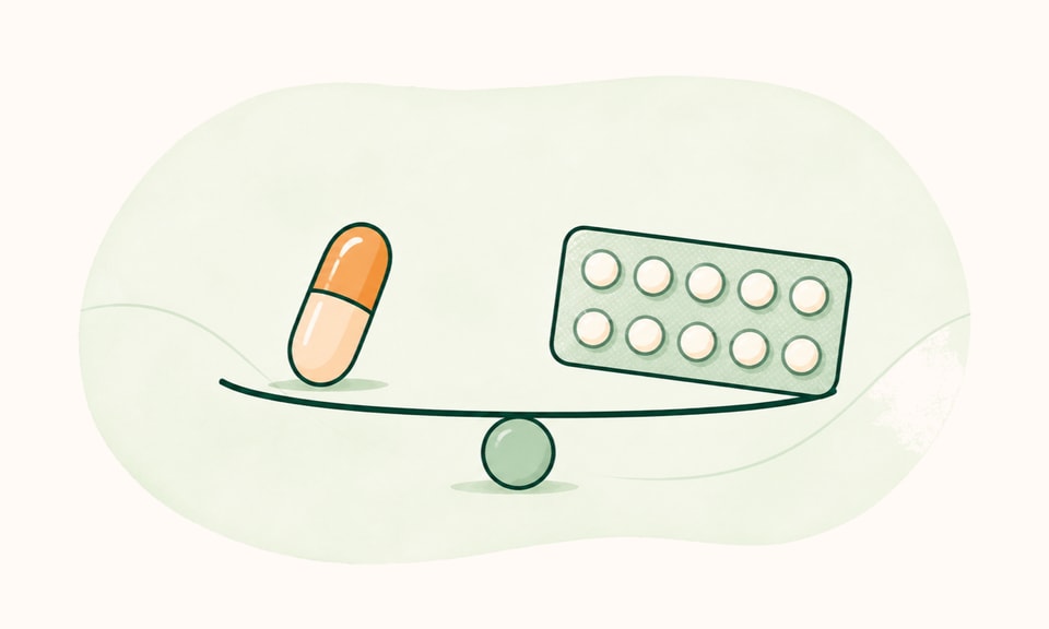 A compact unframed balance of an isotretinoin capsule and a combined-pill blister on a warm cream canvas.